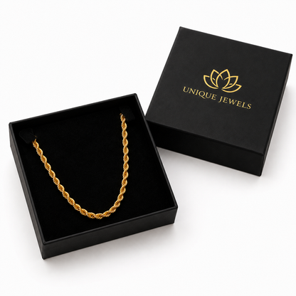 A gold rope-style chain necklace displayed inside an open black jewelry box, with the matching closed box behind it on a white background. The closed box is printed with the brand name 'UNIQUE JEWELS' and a gold lotus logo.