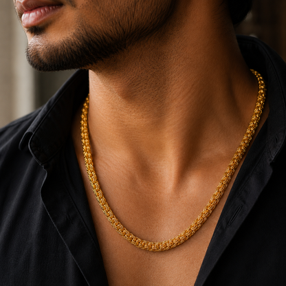 A close-up lifestyle shot of a man wearing a thick, textured gold chain necklace over a black collared shirt.