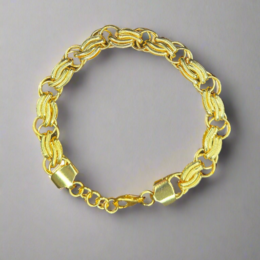 Gold chain bracelet on a gray background