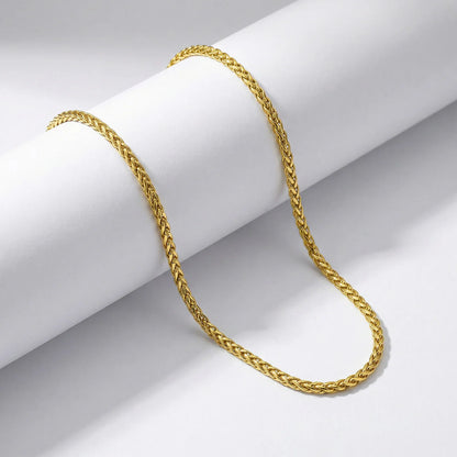 Gold chain on a white cylindrical object with a gray background